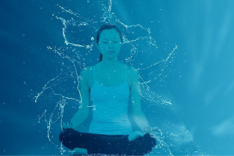 Woman practicing yoga in the water