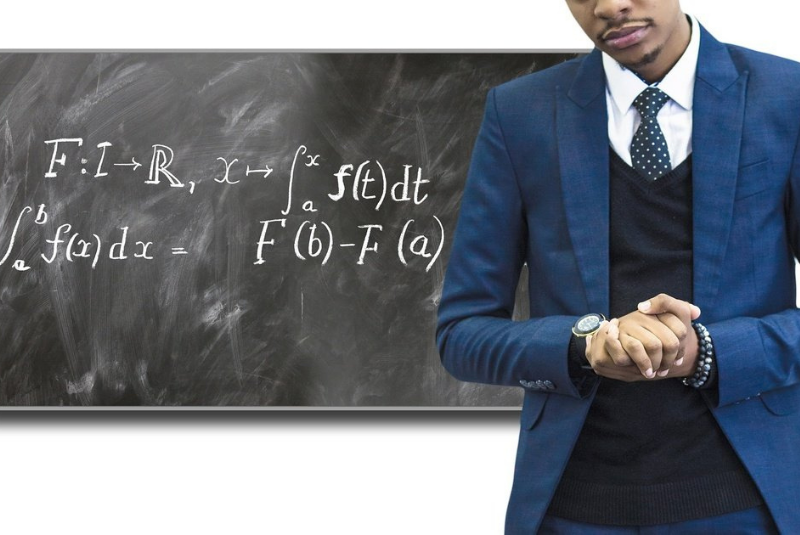 Expert teacher showing a formula on the blackboard